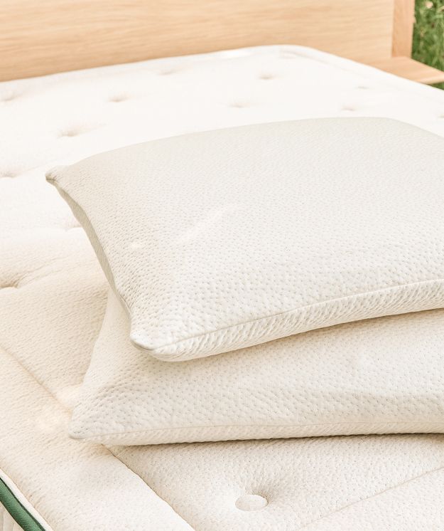 Oreillers en latex naturel Kipli posés sur un matelas écologique en latex, illustrant une literie saine et durable.