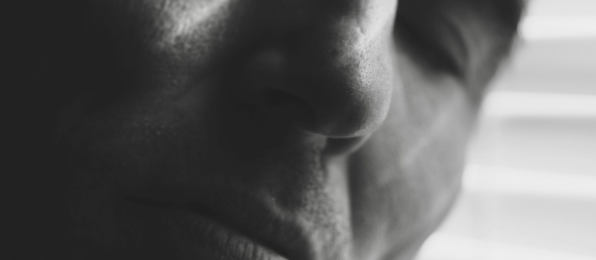 Visage d’une personne endormie en gros plan, photographié en noir et blanc.