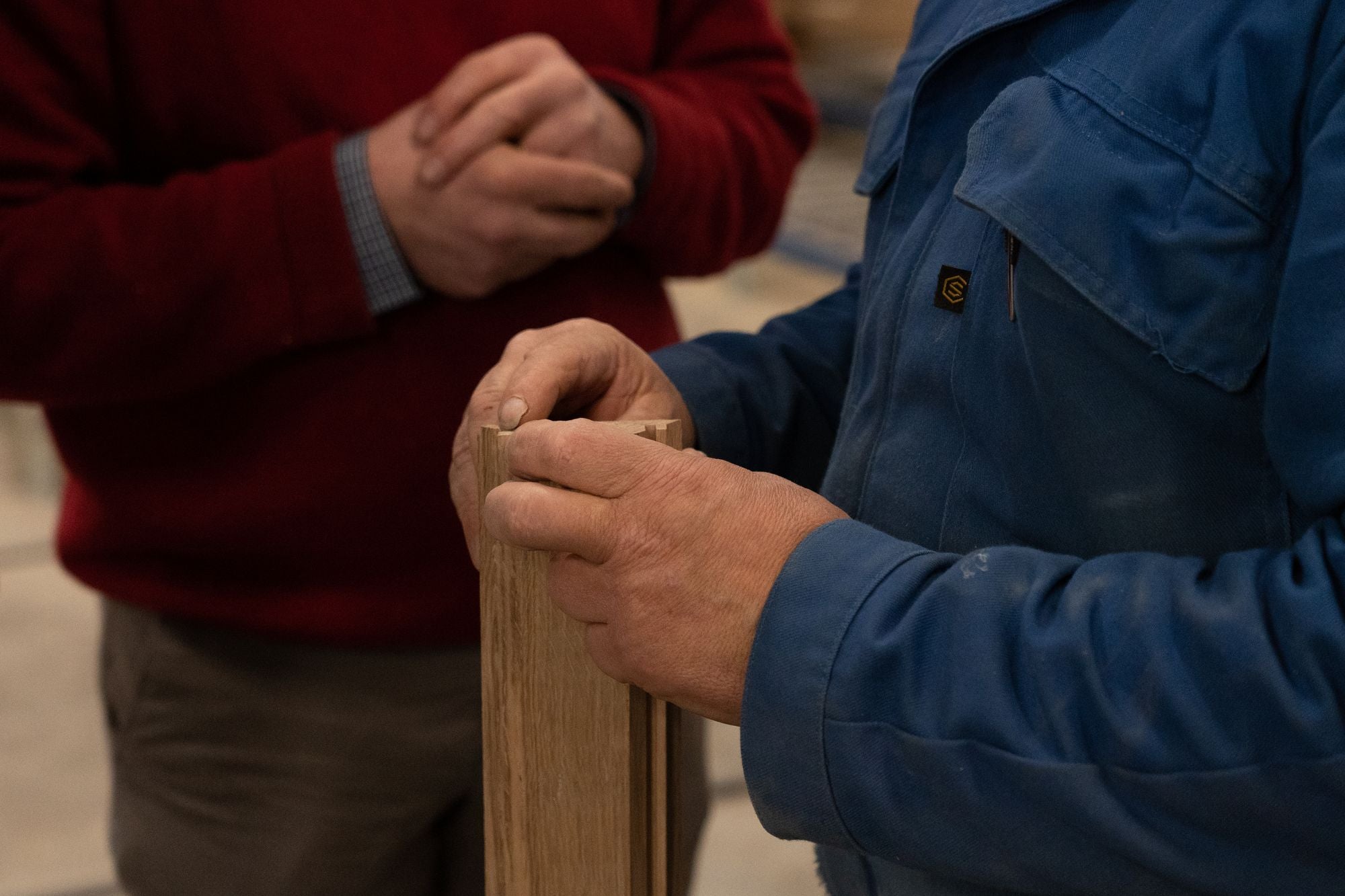 Artisan en atelier manipulant une pièce de bois massif, illustrant le savoir-faire artisanal et la fabrication responsable du mobilier Kipli.